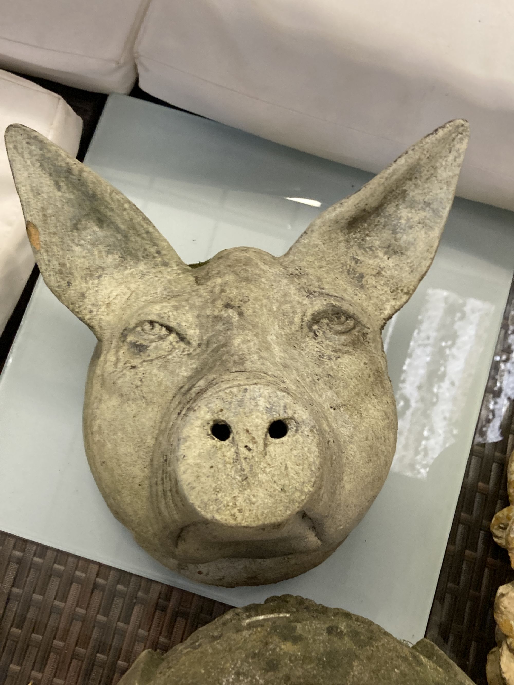 A terracotta pigs head wall applique, height 28cm, a composition bracket and a stone urn